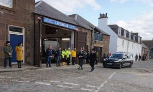 RNLI volunteers pay respects as the procession for Ian Balgowan leaves the Old Pier. Image: Jim Stephen.