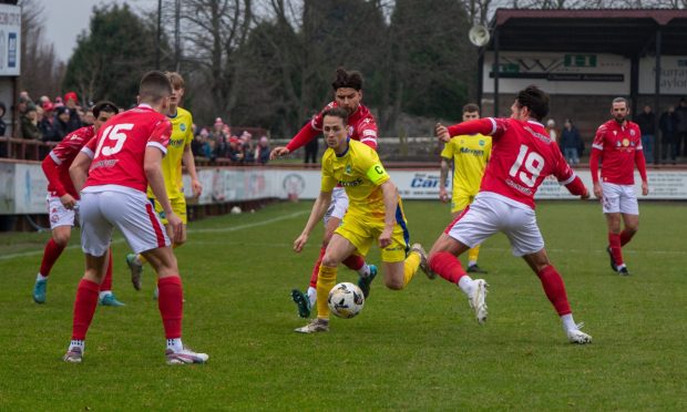 Buckie's Kevin Fraser, centre, tries to evade the challenge of Brechin's Liam Callaghan (number 19), right. Pictures by Kim Cessford /DC Thomson.