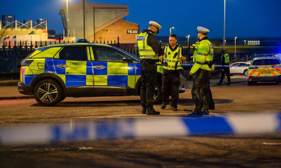 Police tape blocks off Park Road as police car and officers stand at the scene.