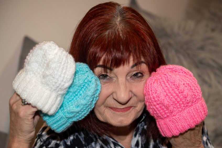 May with some of the tiny hats she has knitted for premature babies. 