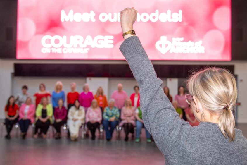 Woman holding up arm in front of blurred out models