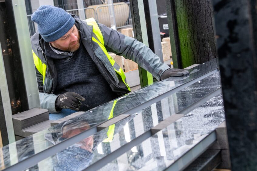 Man in high vis looking at mirror display