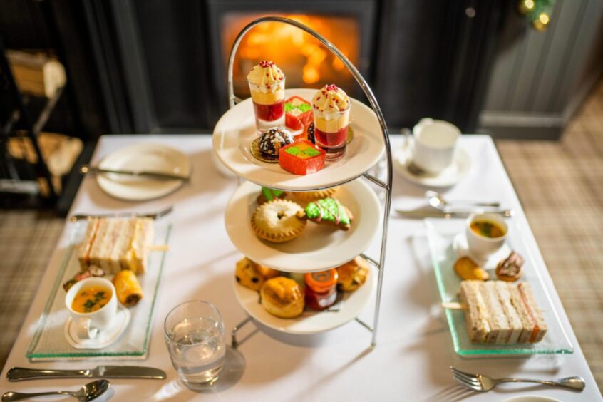 A three-tier plate tree sits on a table at Maryculter House. On the plates are a selection of sandwiches and desserts from the afternoon tea menu.