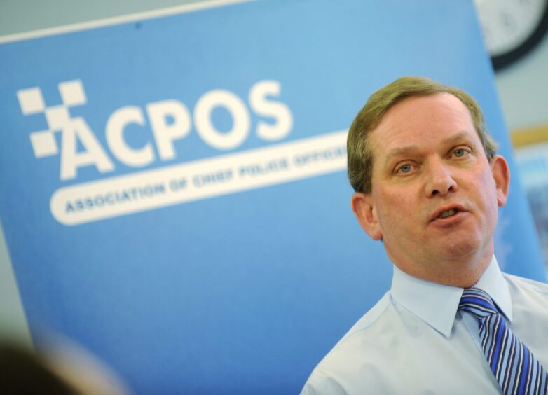 Ian Latimer in front of a blue background.