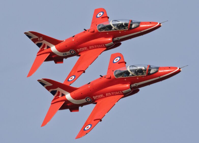 Two Red Arrows aircrafts sid by side.