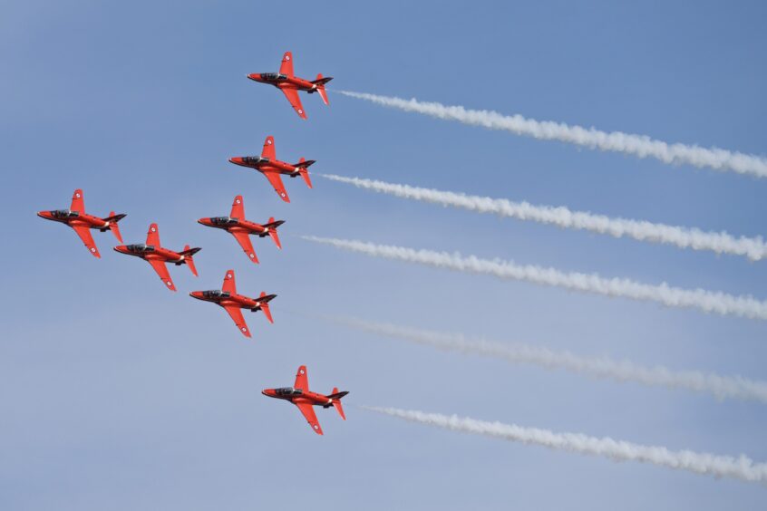 Seven red arrow aircrafts in formation.