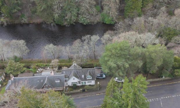 Trees surround 16A Island Bank Road as the river flows behind the house.