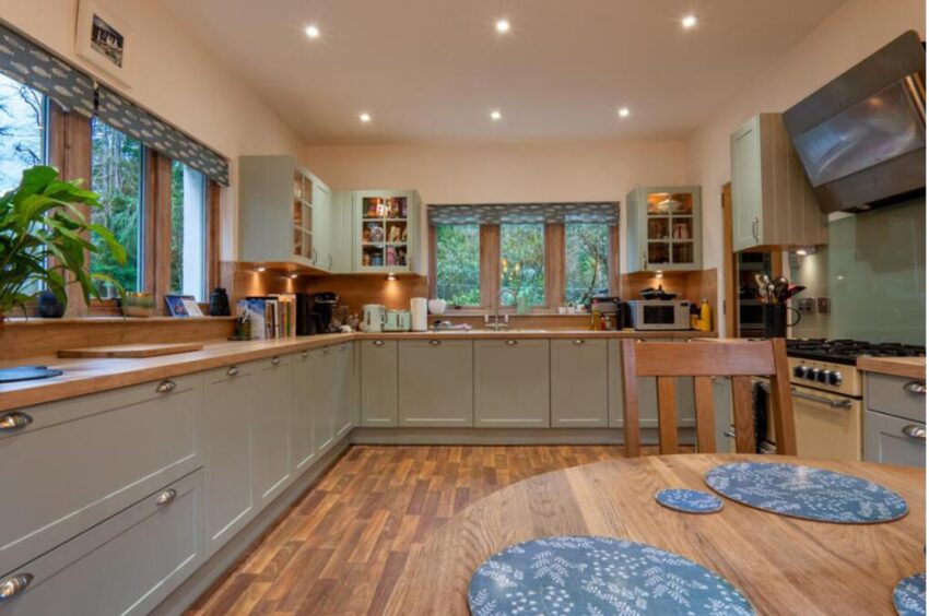 Large kitchen with green worktops.