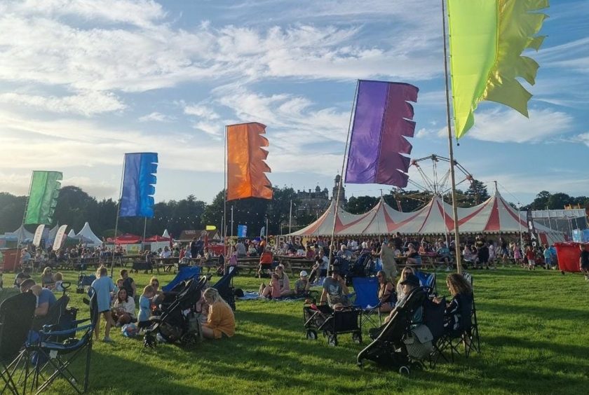 a family friendly festival with blue skies and flags flying