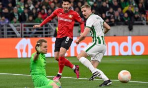 Goalie Denes Dibusz (L) of Ferencvaros in action in front of teammate Mats Knoester (R) and Sardar Azmoun (C) of Bayer Leverkusen during the soccer Europa League round of 16 second leg Image: Shutterstock.