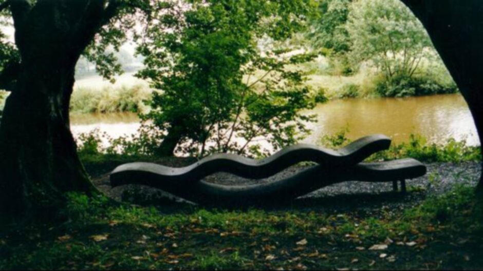 a bench, trees and water at Ness Islands in Inverness, which is great for cycling