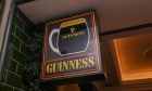 A Guinness sign hanging over the entrance to Aberdeen pub O'Malley's Irish Bar & Kitchen