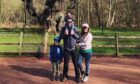 Family standing in front of a tree