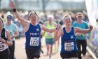 Tony and Beverley celebrate crossing the line in the Inverness Half Marathon. Image: Paul Campbell