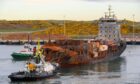 The burnt out Solong container ship being tugged into Aberdeen's South Harbour. Image: Kenny Elrick/DC Thomson