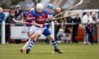 Kingussie's Roddy Young in front of Newtonmore's Daniel Sloss. Image: Neil Paterson.