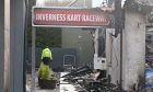 Police office stands beyond sign of Inverness Kart Raceway.