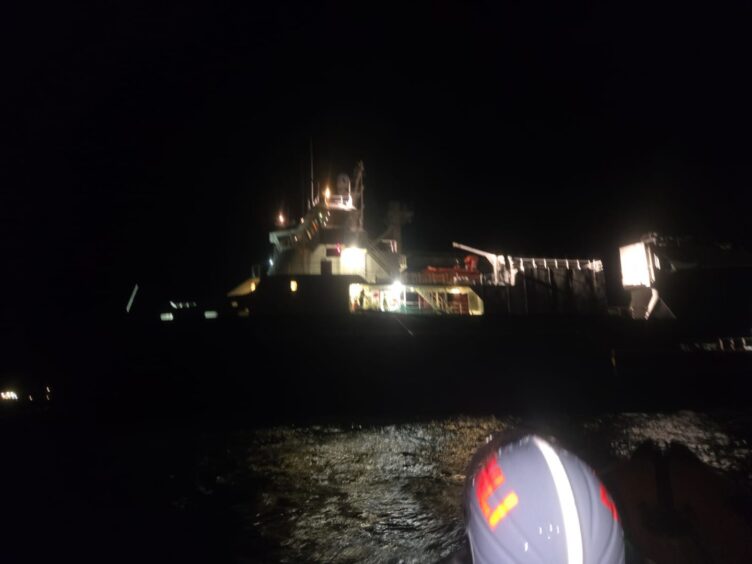 RNLI helmet in front of cargo ship in water