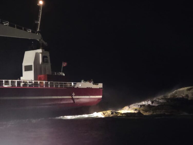 Cargo ship next to rocks