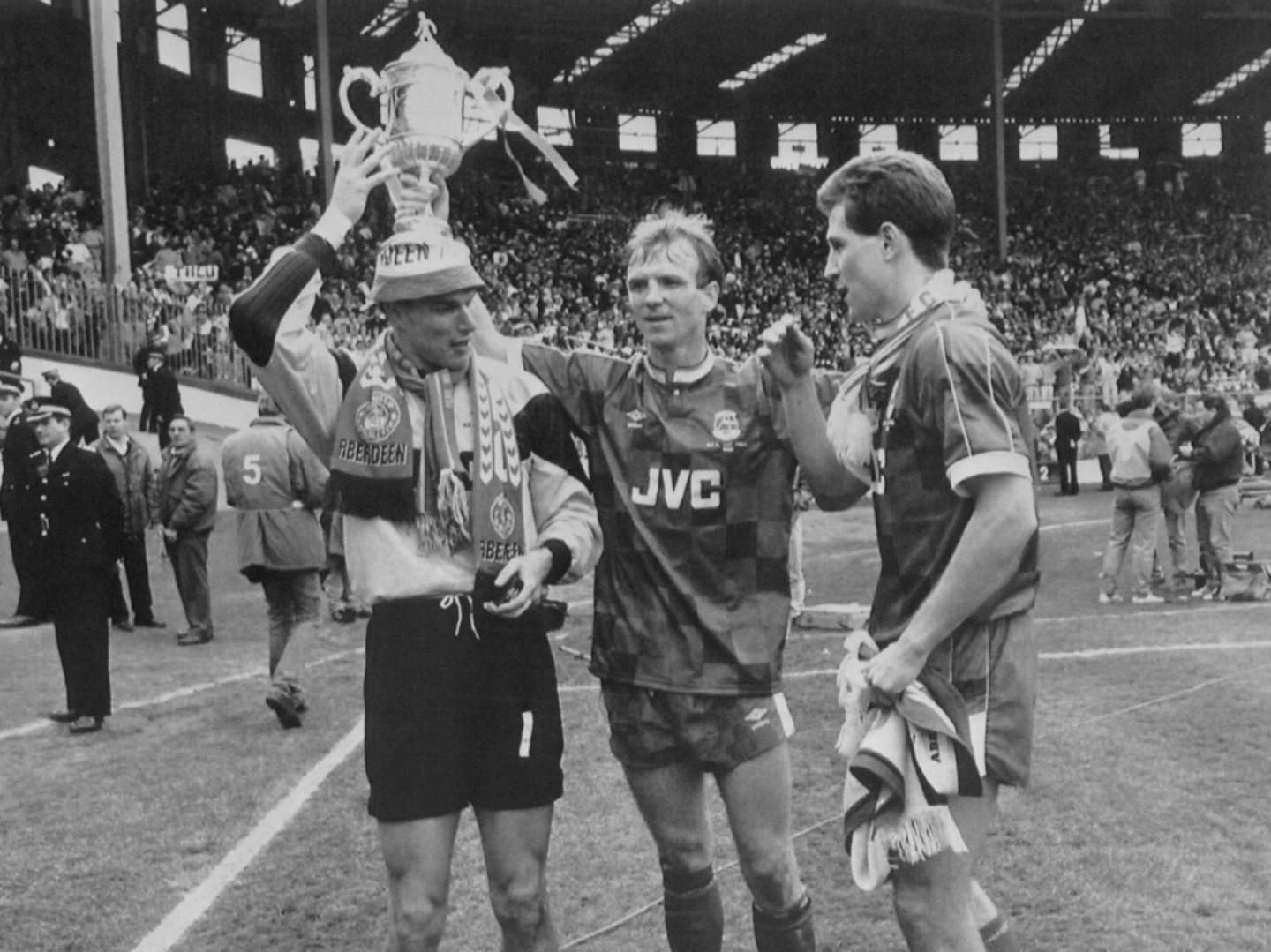 Aberdeen's goalkeeper Theo Snelders (l), captain Alex McLeish (c) and Brian Irvine (r) celebrate with the cup after beating Celtic 9-8 on penalties