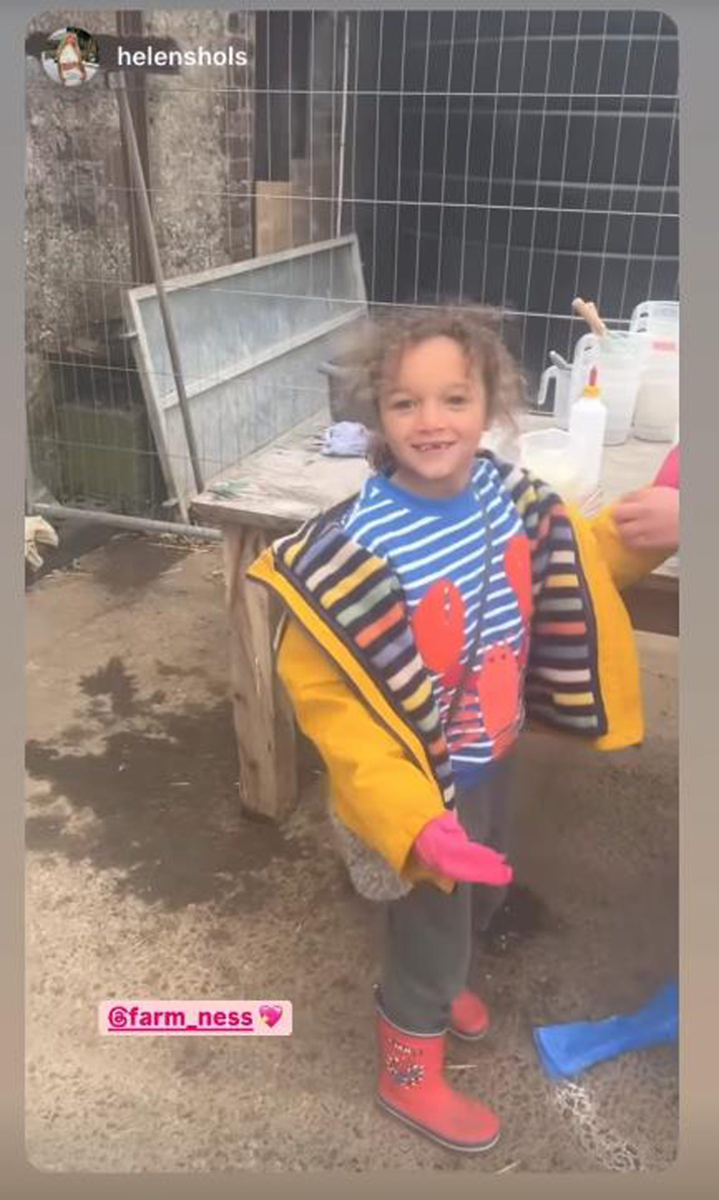 Delilah wearing a blue and white striped jumper and a yellow coat. 