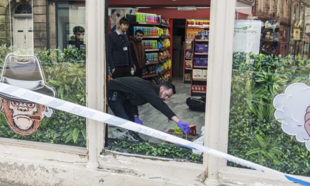 Police officer wearing Purple Gloves investigating at Elgin vape shop.