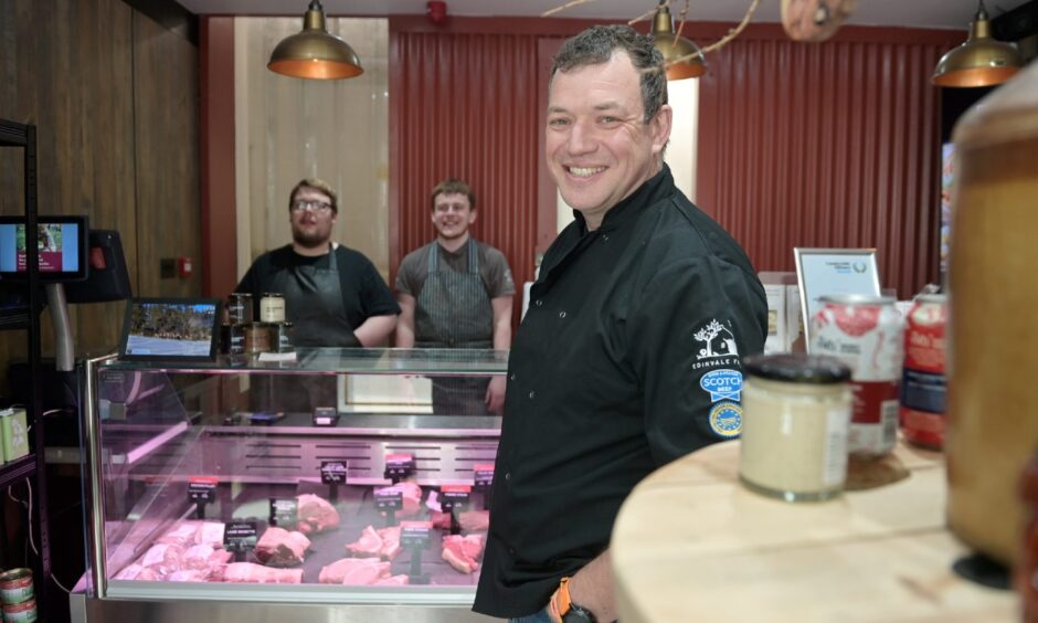 Jock Gibson standing at counter with staff behind. 