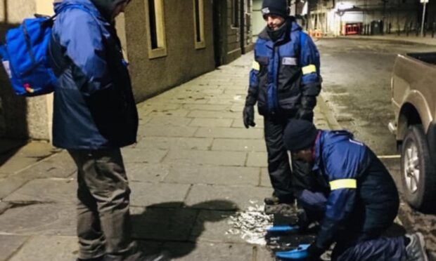 Orkney Street Pastors Sweeping up glass in Kirkwall. Image: Barry Cockerham.