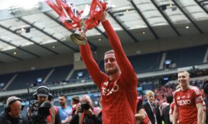 Alfie Dorrington of Aberdeen celebrates at the end of the match with the Scottish Cup. Image: Shutterstock.