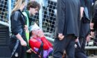 Aberdeen's Jack MacKenzie receives treatment after being hit with an object from the crowd. Image: SNS
