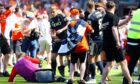 Aberdeen's Jack MacKenzie is hit with a chair from the crowd at Tannadice. Image: SNS.