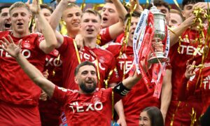 Aberdeen captain Graeme Shinnie lifts the Scottish Cup at Hampden after a dramatic penalty shoot-out win against Celtic. Image: SNS