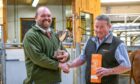 Bulling heifer cup winner Ewan McCall, left,
with judge Colin Little. Image: Luing Cattle Society