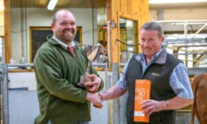 Bulling heifer cup winner Ewan McCall, left,
with judge Colin Little. Image: Luing Cattle Society