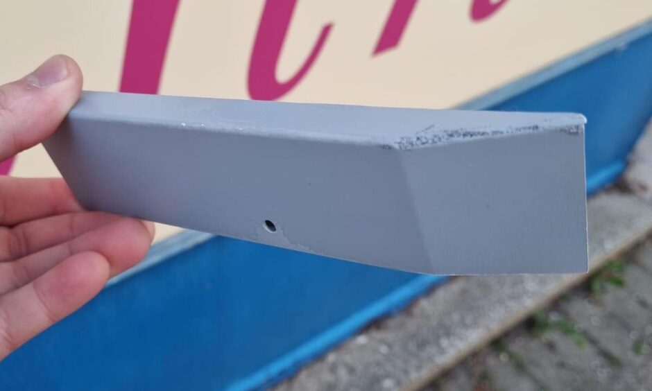 Hand holding grey wooden block