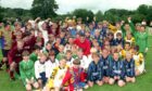 The under-12s Soccer Sevens team get together with Dons stars Darren Young, Malcolm Kpedekpo and Aberdeen FC community coach Chic McLelland to celebrate a successful 1997 Aberdeen International Football Festival tournament at Seaton Park. Image: DC Thomson Archives.