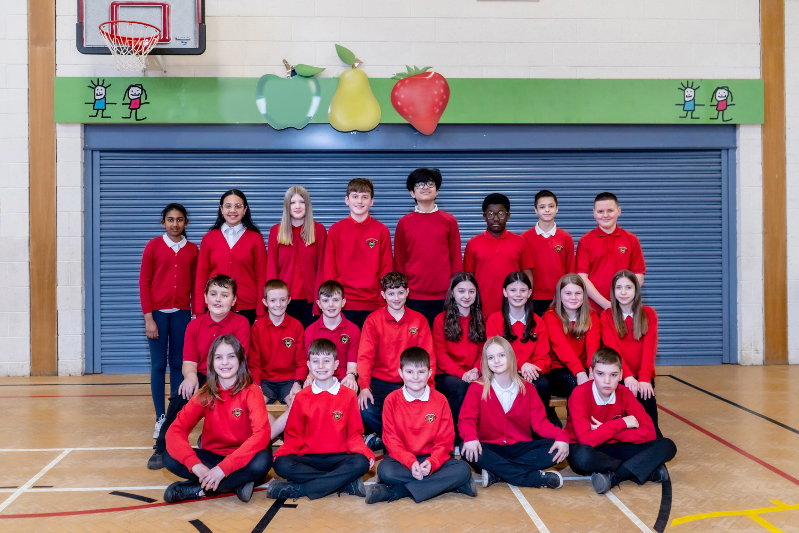 Three rows of school pupils in red sweatshirts.