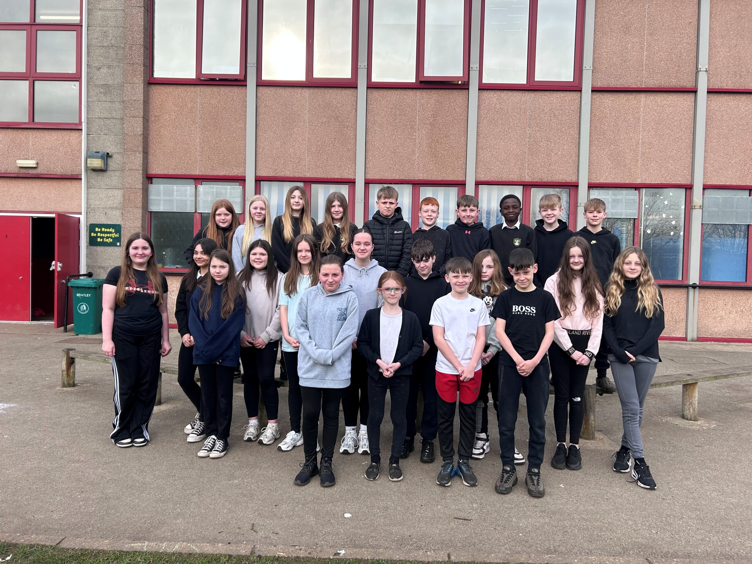 A group of pupils in the school playground facing the camera.