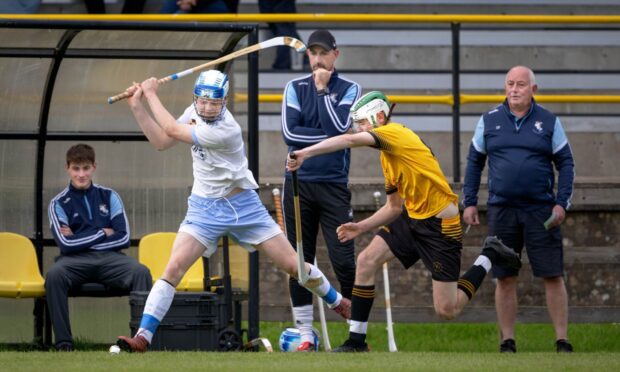 Fort William's Archie Mackinnon (right) tries to block the swing of Seonaidh MacLeod (Skye). Image: Neil Paterson.