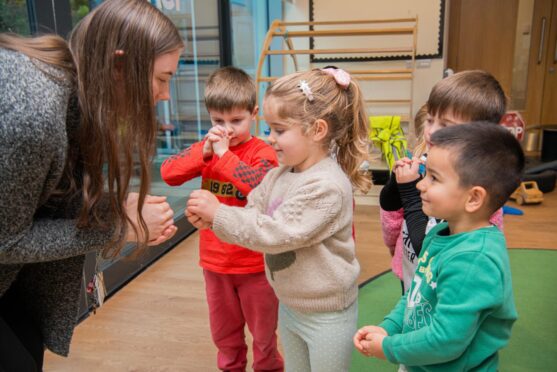 Teacher interacting with children at nursery.
