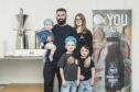 Conor Stewart and his wife Iona with their kids Conor, baby Cash and Cauley Stewart pictured inside the factory. Image: Jason Hedges/DC Thomson