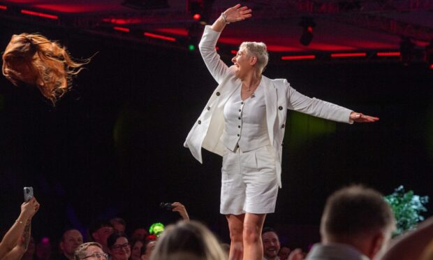 The moment that sums up Courage on the Catwalk. Kelly Butler throws her wig into the crowd. Image: Kami Thomson/DC Thomson