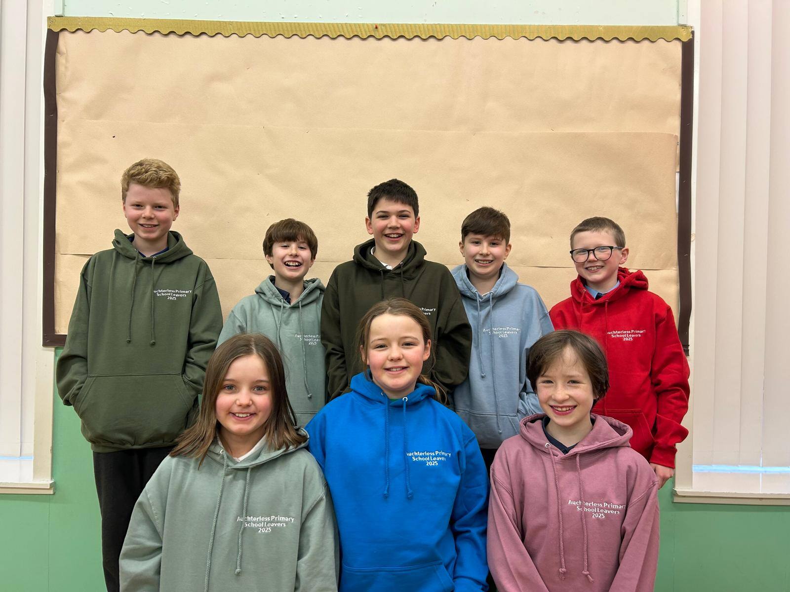 Eight P7 Auchterless pupils in school hoodies of different colours
