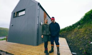 A man and a woman stand close together in front of their home which featured on Scotland's Home of the Year