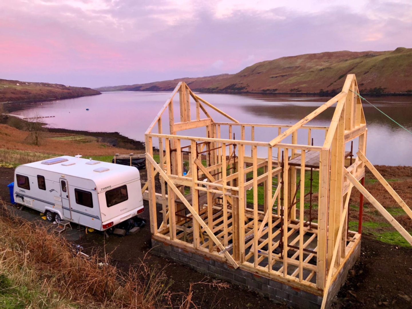 Scotland's Home of the Year's Skye cabin as just a wooden frame, with a caravan next to it.