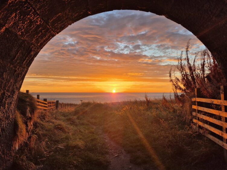 A striking orange sunset seen from Cove Bay coastal path.