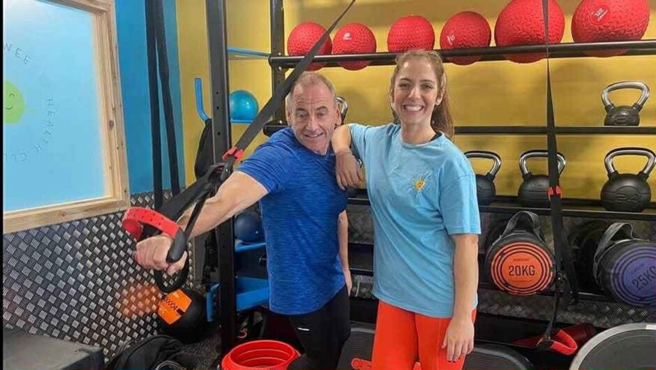 Instructor Ian Milarvie and Katie Galbraith in front of a rack of kettlebells in the gym space at the Happy Wee Health Club