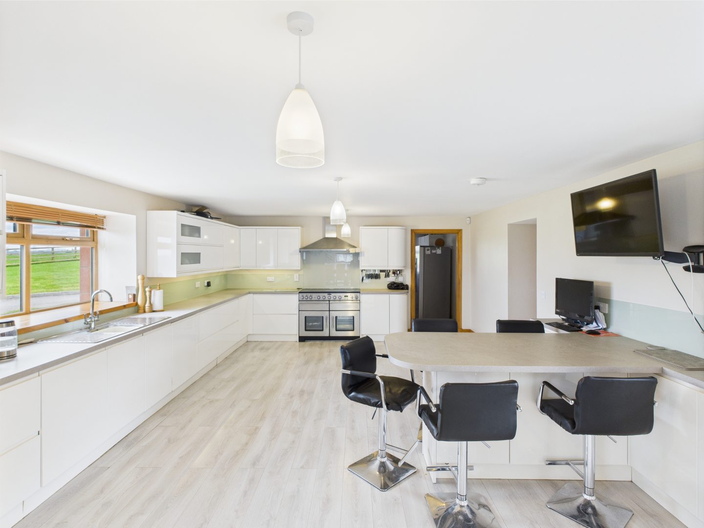 A white kitchen with island and TV