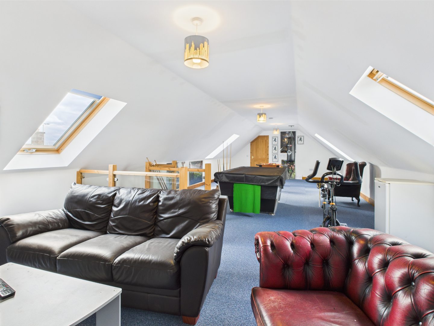 A view of sofas and a snooker table in the upper floor of The Steadin.