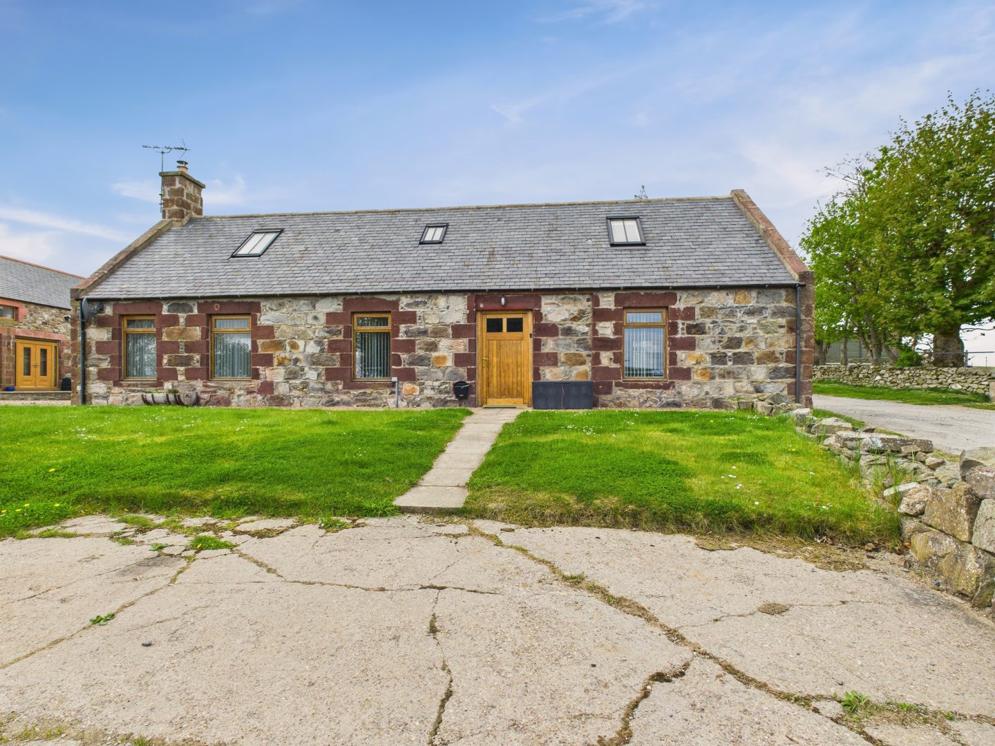 A stone walled cottage with a tiled roof.